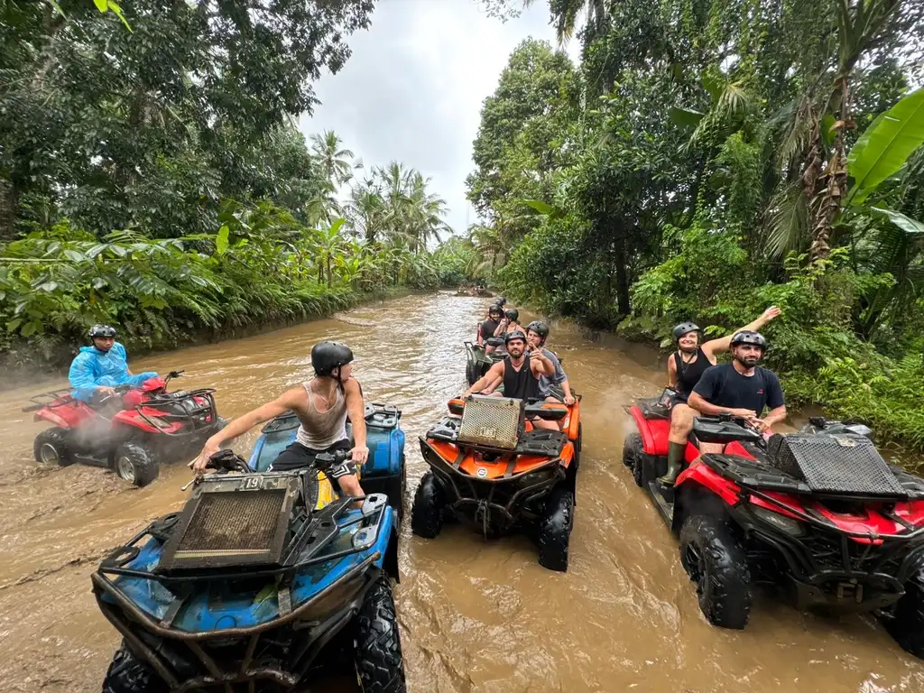 Guests riding ATVs through a jungle river crossing in Ubud