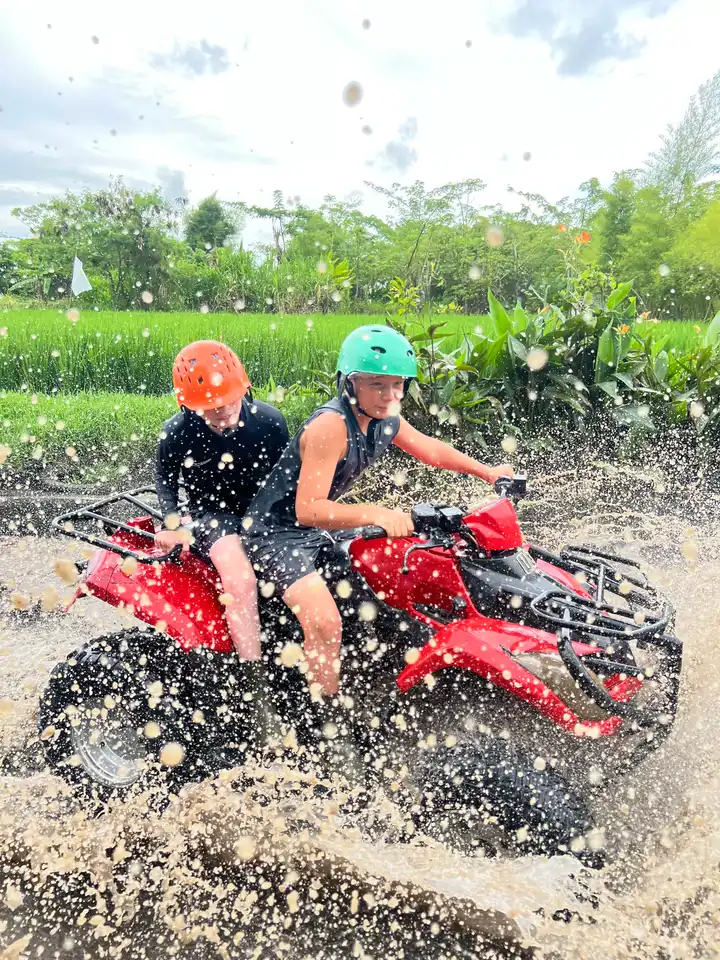 A family riding an ATV through a splash on an Ubud day trip