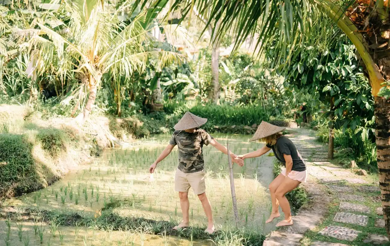 A couple planting rice on a Bali village adventure